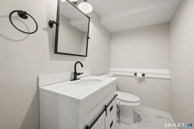a bathroom with a sink mirror and toilet
