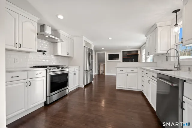 a kitchen with white cabinets stainless steel appliances and sink