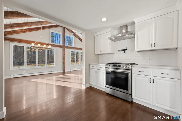 a kitchen with stainless steel appliances granite countertop a stove and a white cabinets