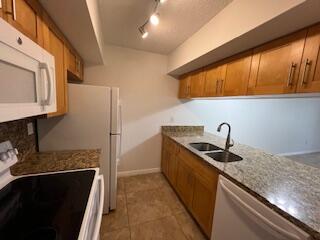 18206 Mediterranean Boulevard, Unit 421 Hialeah, FL 33015 - Photo 15 of 22 a kitchen with stainless steel appliances granite countertop a sink stove and refrigerator