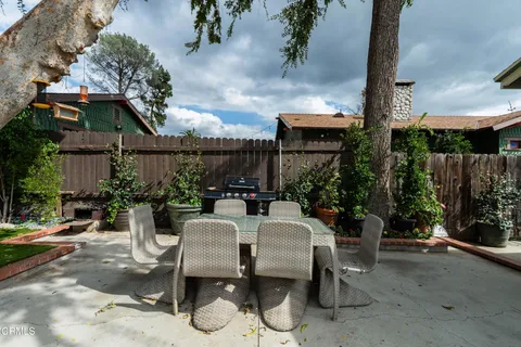 a view of a patio with table and chairs potted plants