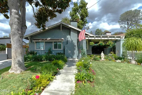 a front view of a house with a yard and potted plants