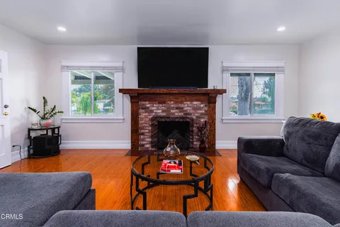 a living room with furniture a flat screen tv and a fireplace