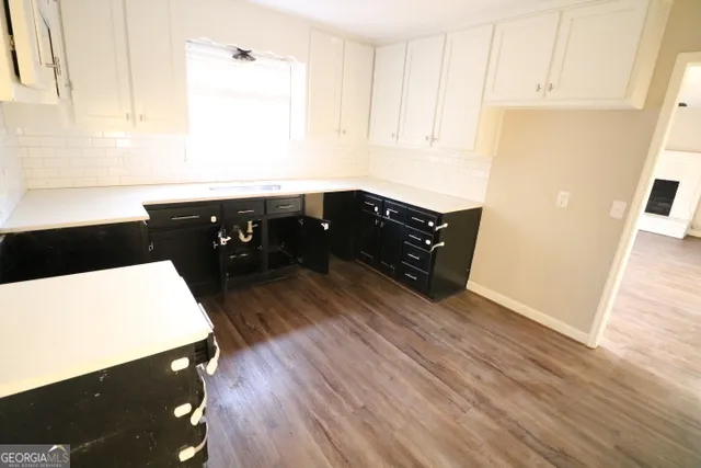 a kitchen with a sink a stove and wooden floor