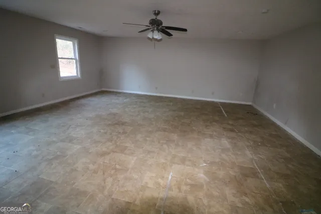 an empty room with a window and a ceiling fan