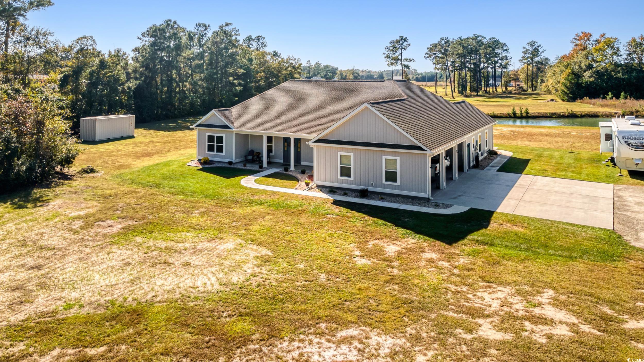 Front view of property with covered porch, a yard,