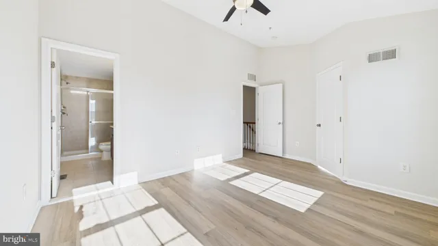 an empty room with wooden floor and windows