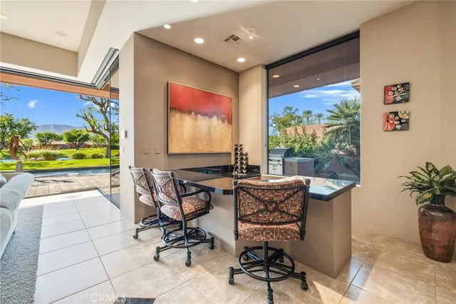 a view of a workspace with furniture and a floor to ceiling window