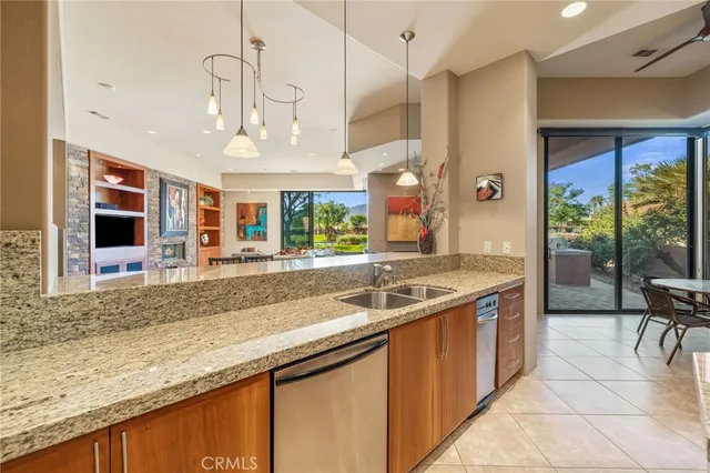 a kitchen with stainless steel appliances granite countertop a sink and a refrigerator