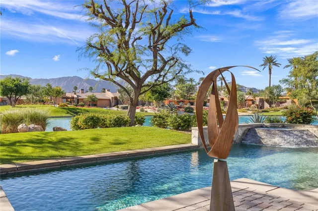a view of a swimming pool with a lawn chairs under an umbrella