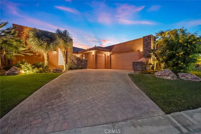 a view of a swimming pool with lawn chairs under an umbrella