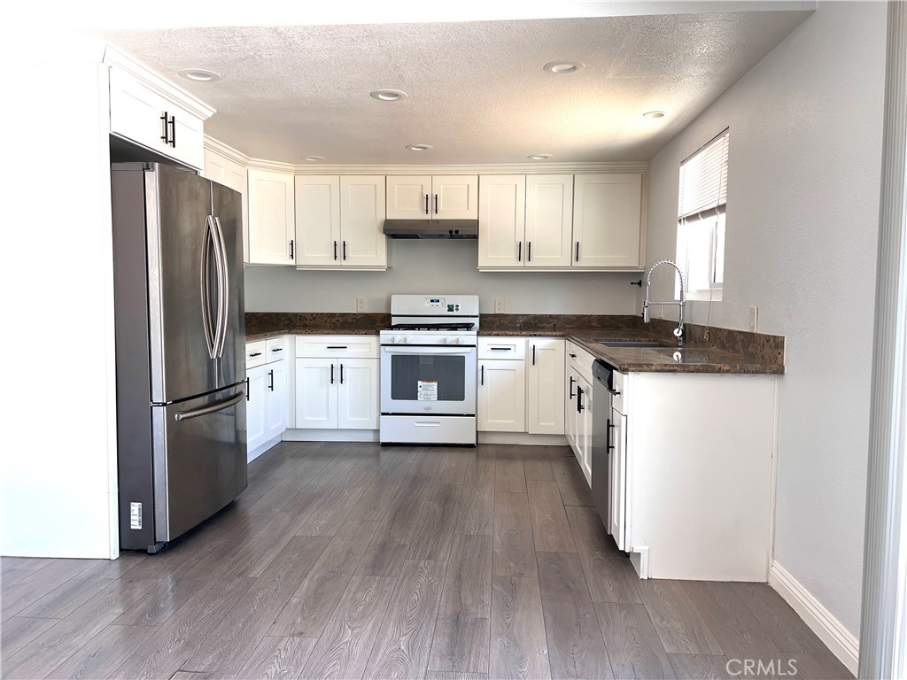 2061 Rancho Drive Riverside, CA 92507 - Photo 4 of 19 a kitchen with a refrigerator a sink and wooden floor
