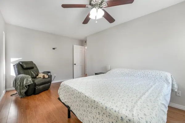 a spacious bedroom with a bed and ceiling fan