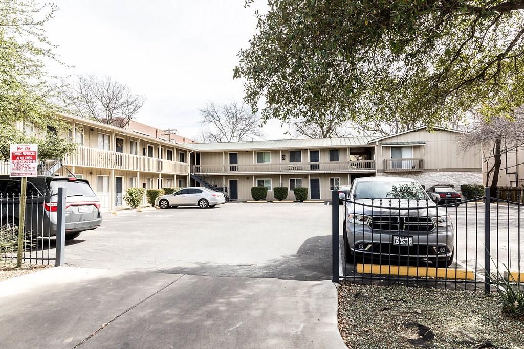 A wide, paved parking lot provides ample guest and resident parking for this multi-level residential complex.