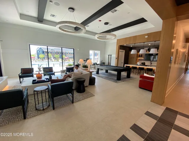 a kitchen with stainless steel appliances granite countertop a sink dishwasher a stove and a dining table with wooden floor