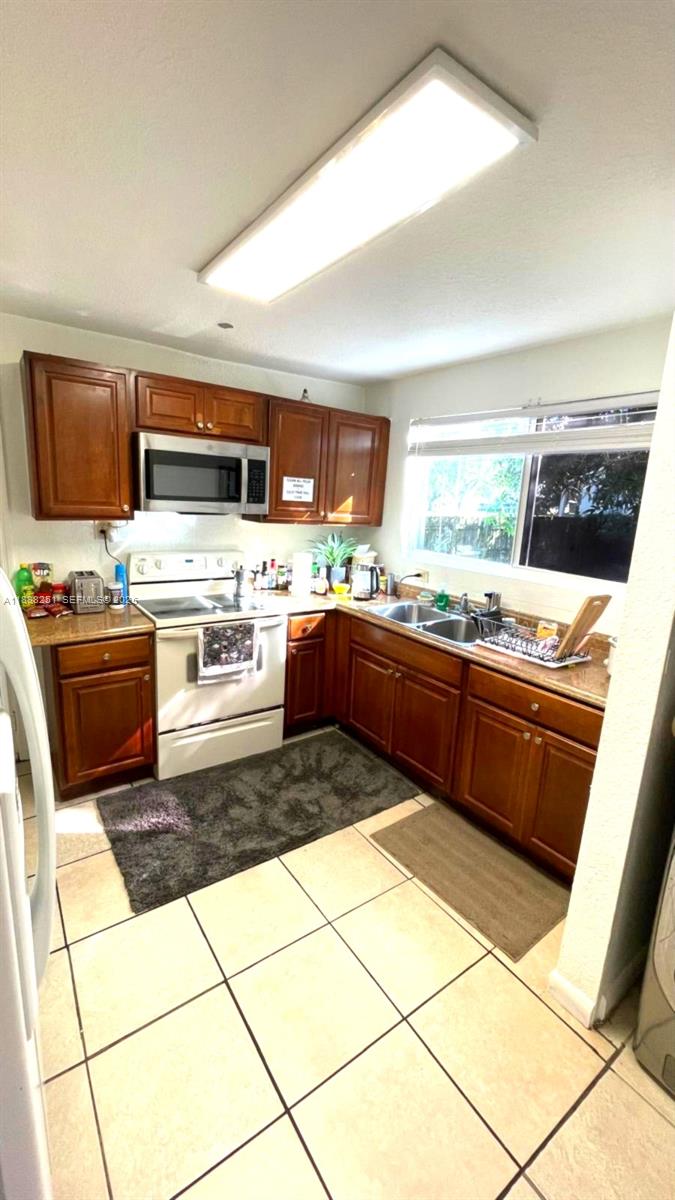 3 Southwest 7th Avenue Dania Beach, FL 33004 - Photo 6 of 25 a kitchen with stainless steel appliances a stove a sink and a refrigerator