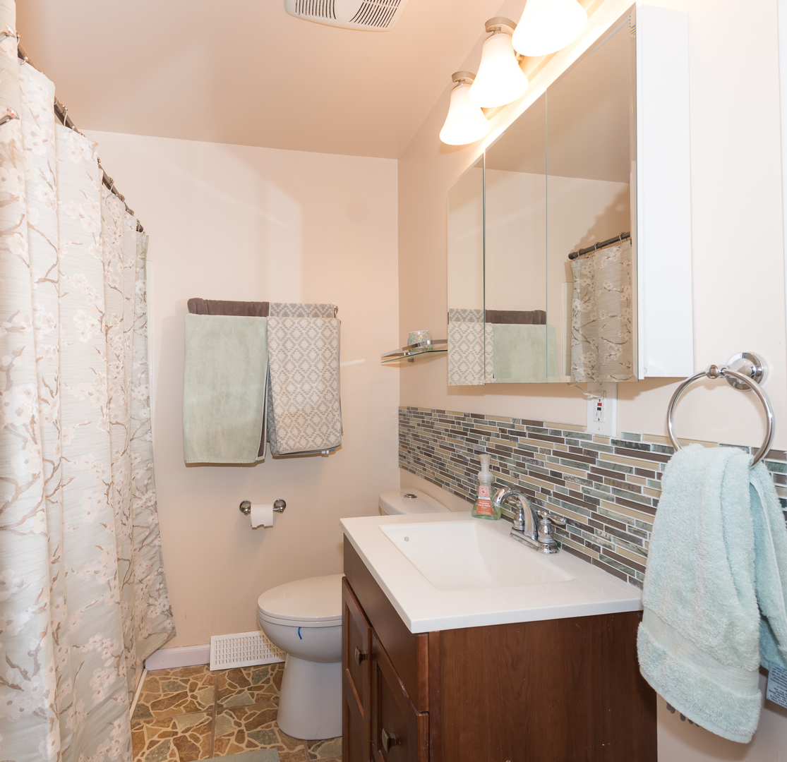 1S183 Valley Road Lombard, IL 60148 - Photo 11 of 25 a bathroom with a sink toilet and mirror