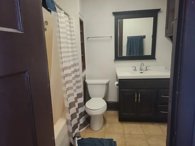 a bathroom with a toilet sink and mirror