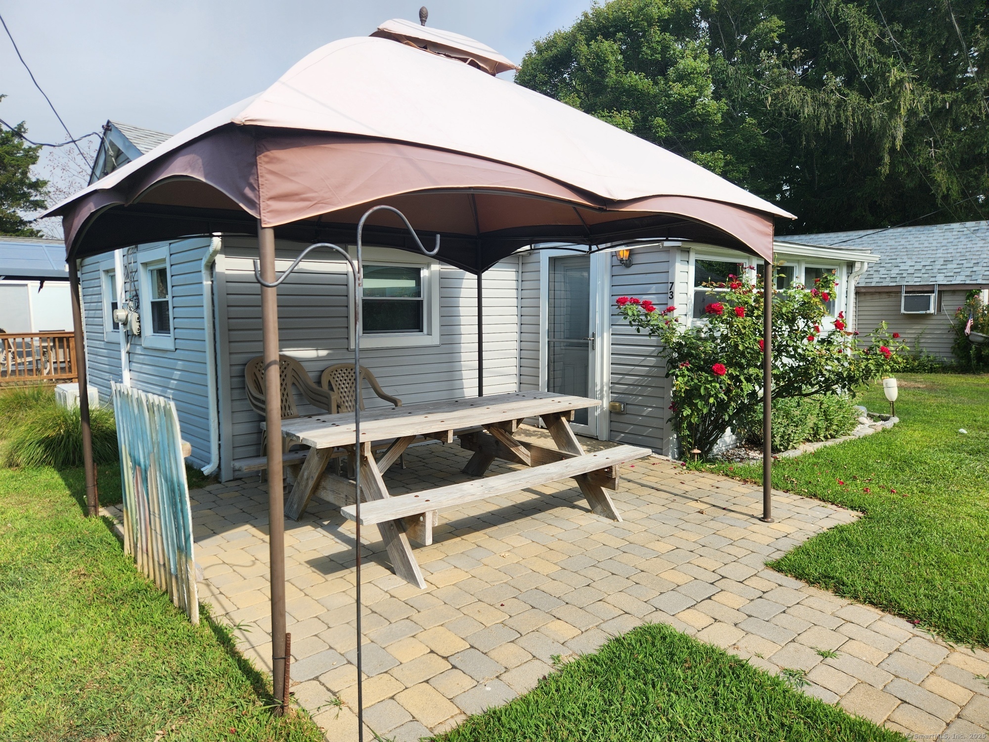 73 South Street Madison, CT 06443 - Photo 1 of 1 a patio with a table and chairs under an umbrella