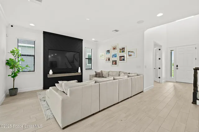 a view of a hallway with wooden floor and windows