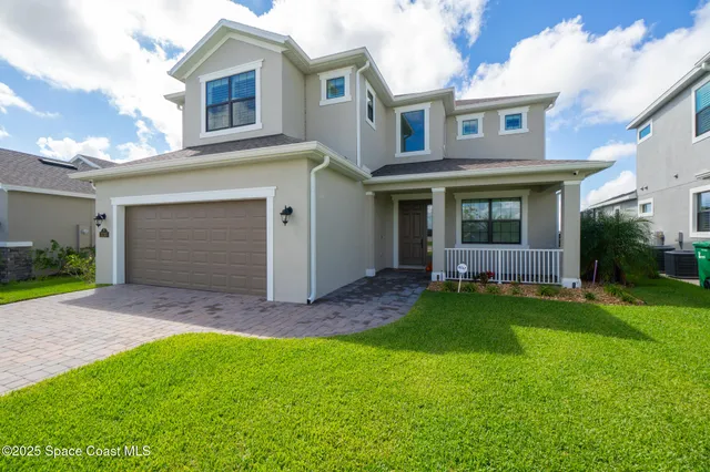 a view of an house with backyard and a tree