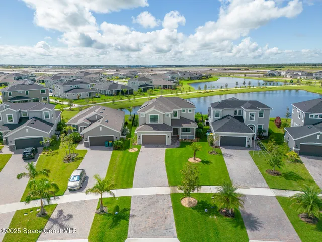 an aerial view of a swimming pool with lawn chairs