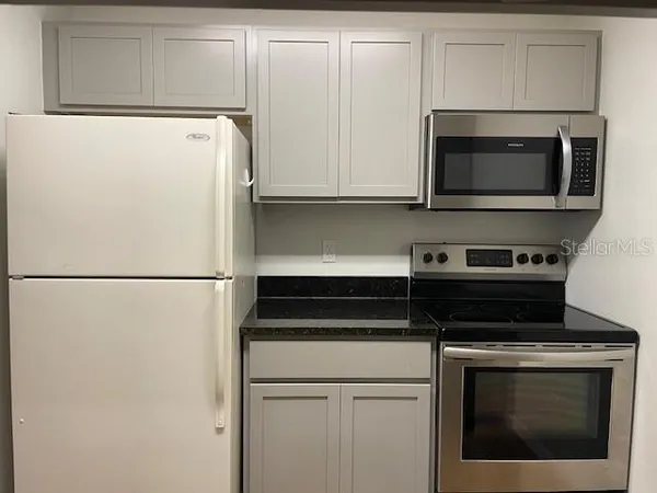a kitchen with cabinets and stainless steel appliances