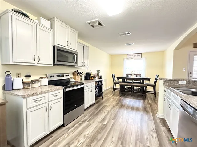 a kitchen with refrigerator and cabinets