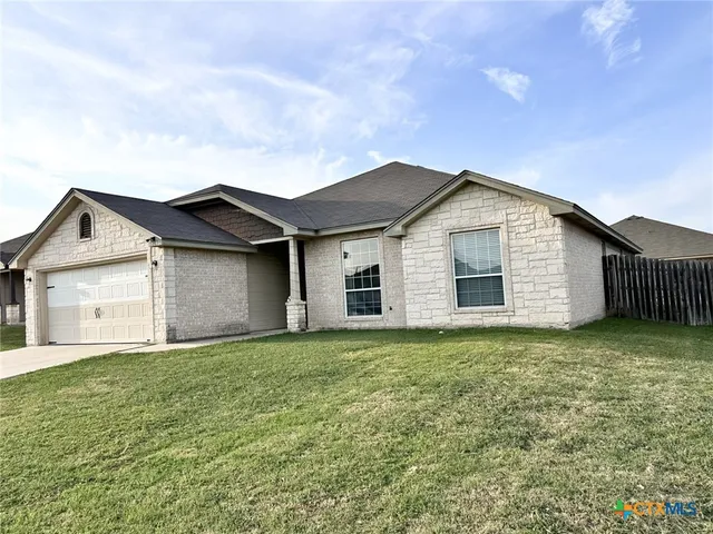 a view of white house with a big yard and garage