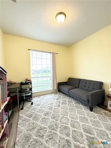 a living room with a bed furniture and next to a window