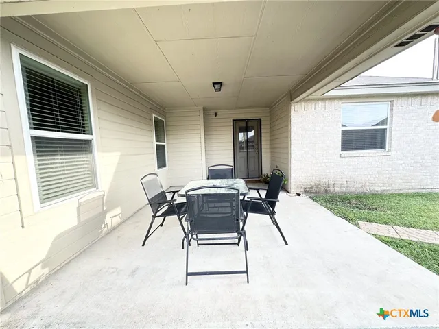 a view of a house with a yard and sitting area