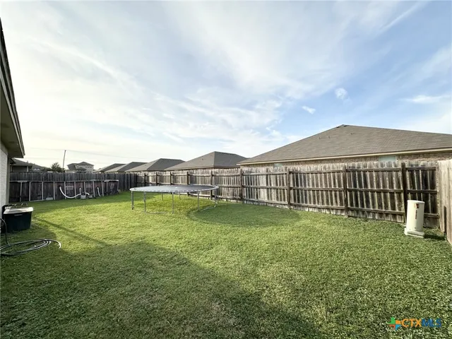 a view of a backyard with wooden fence