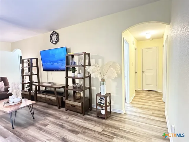 a living room with furniture kitchen view and a large window