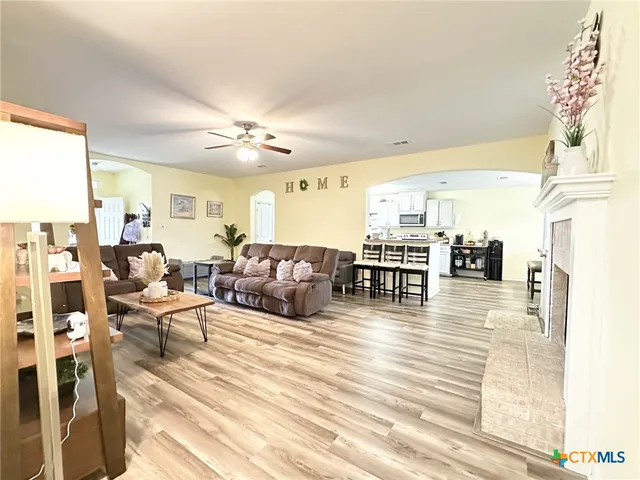 a living room with furniture a fireplace and wooden floor