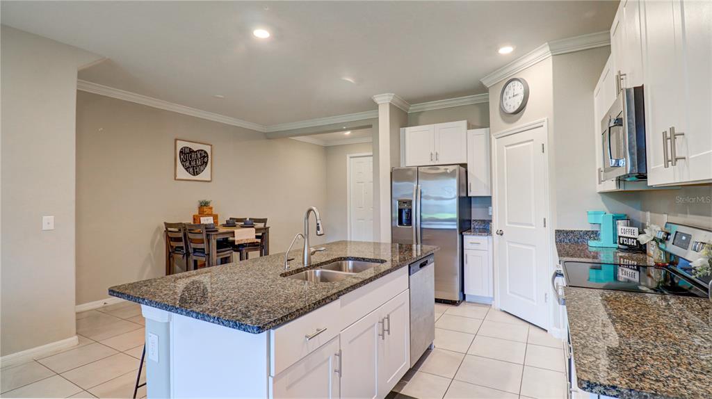 31632 Blue Passing Loop Wesley Chapel, FL 33545 - Photo 14 of 48 a kitchen with stainless steel appliances granite countertop a sink stove and refrigerator