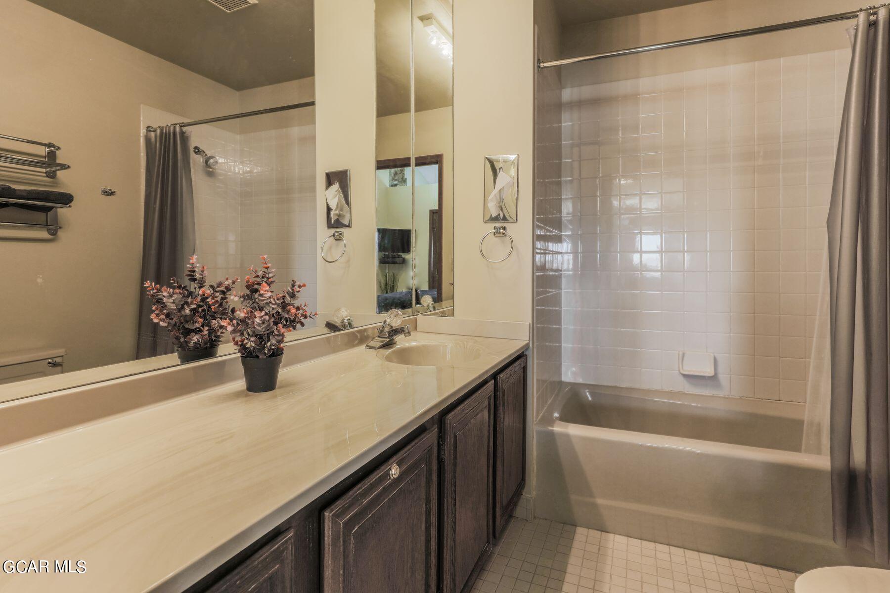 96 Mountainside Drive, Unit B 58 Granby, CO 80446 - Photo 25 of 42 a bathroom with a granite countertop sink a mirror and a bathtub