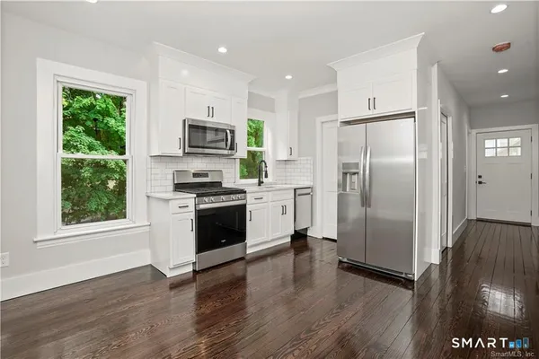 a kitchen with stainless steel appliances a refrigerator sink and microwave