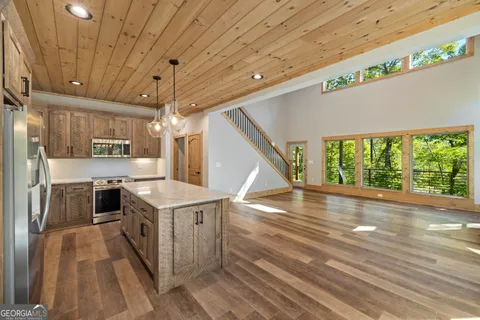 a open kitchen with a stove a sink and a refrigerator