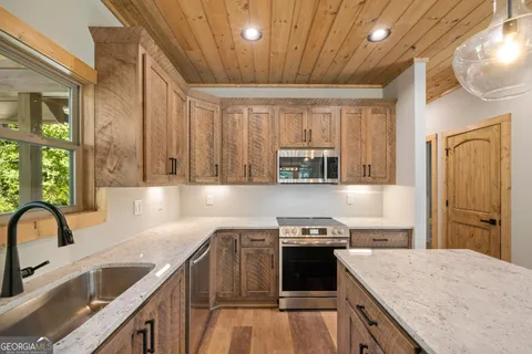 a kitchen with stainless steel appliances granite countertop a sink stove and refrigerator
