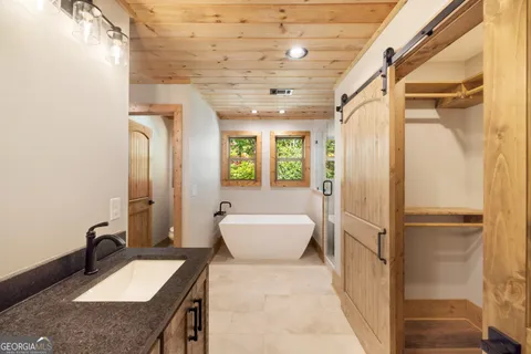 a bathroom with a sink double vanity mirror and bathtub