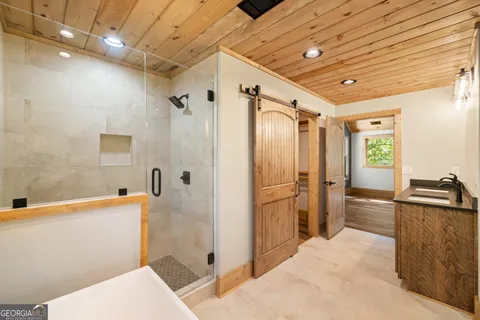 a bathroom with a sink a toilet a mirror and shower