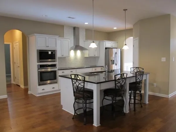 a kitchen with a table chairs microwave and refrigerator