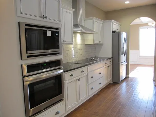 a kitchen with stainless steel appliances white cabinets and a stove top oven
