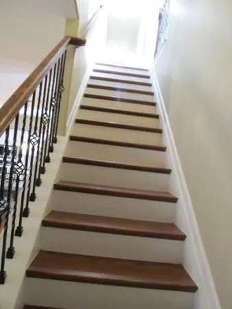 an empty room with a chandelier fan and windows