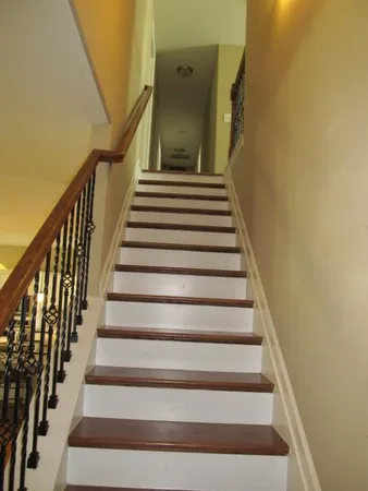 an empty room with a chandelier fan and windows