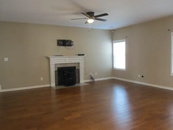 an empty room with a fireplace and windows