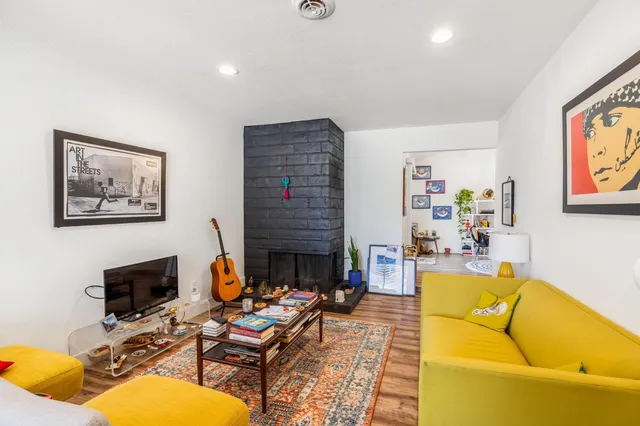 a living room with furniture fireplace and dining table