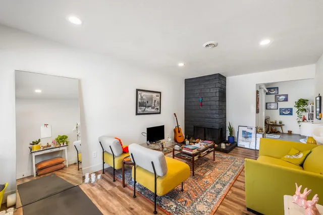 a living room with fireplace furniture and a rug