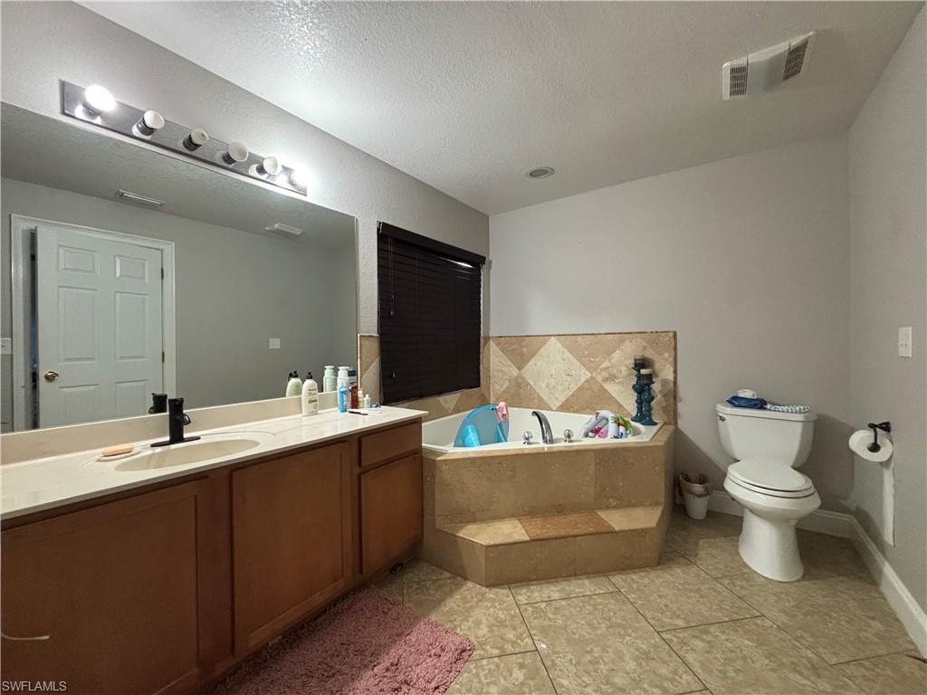 1243 Madison Court Immokalee, FL 34142 - Photo 14 of 32 a bathroom with a sink and mirror