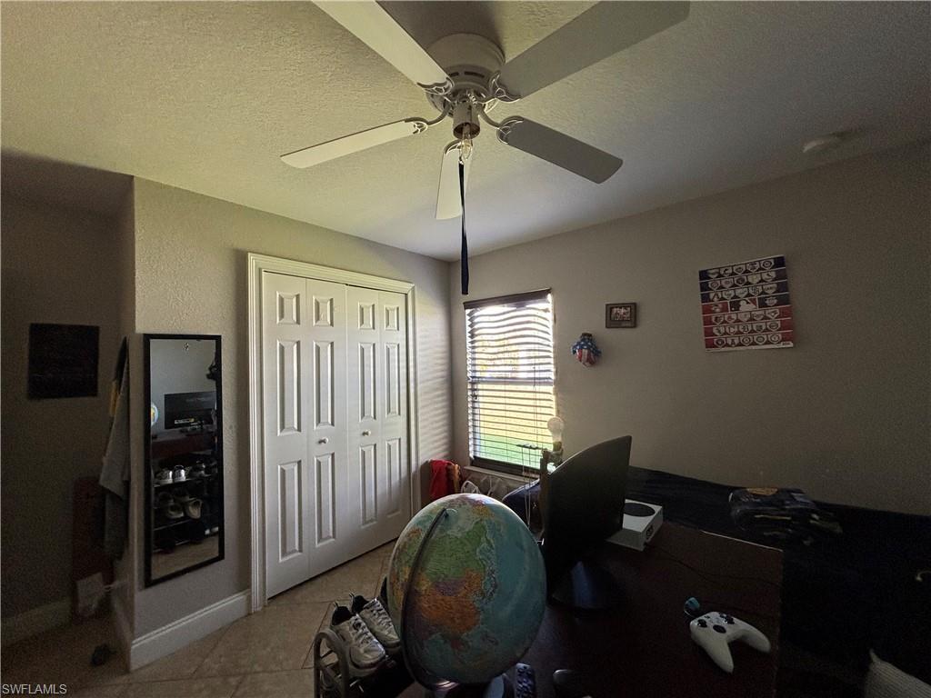 1243 Madison Court Immokalee, FL 34142 - Photo 20 of 32 a bedroom with a bed and a chandelier